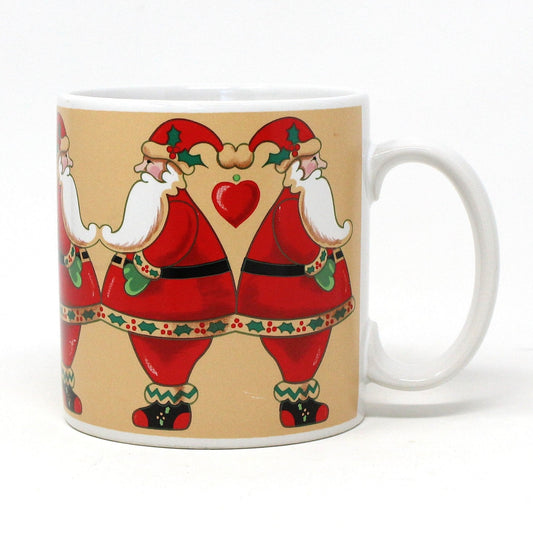 A ceramic coffee mug with a vintage Christmas design featuring two santas and hearts on a beige background.