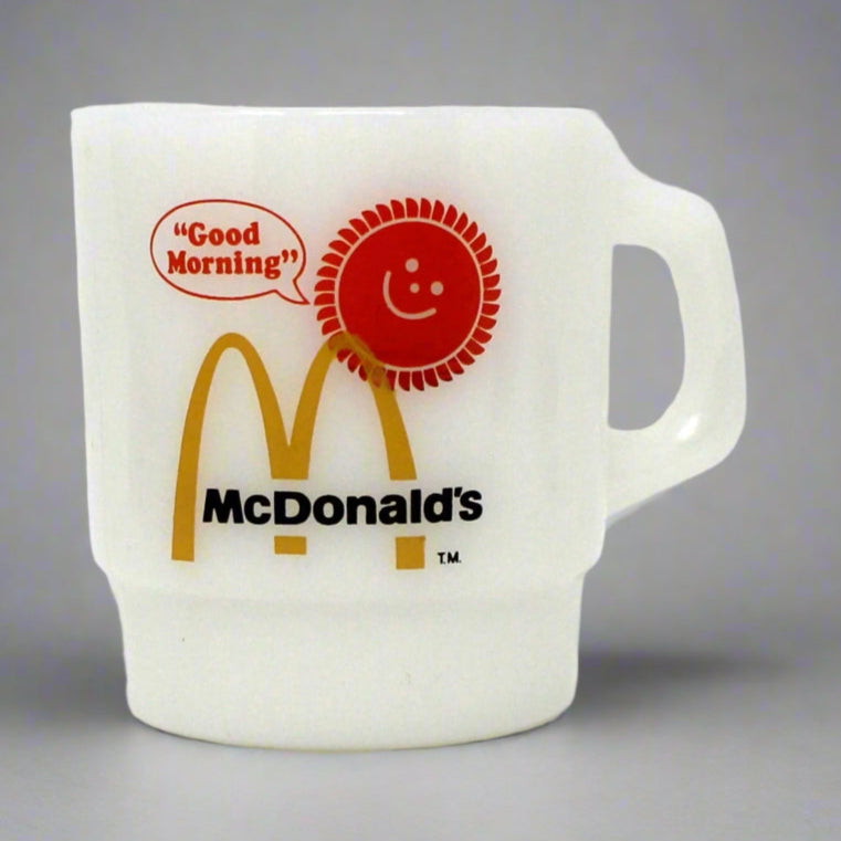 A vintage white glass mug with the McDonald's Good Morning logo and the Golden Arches below the handle.
