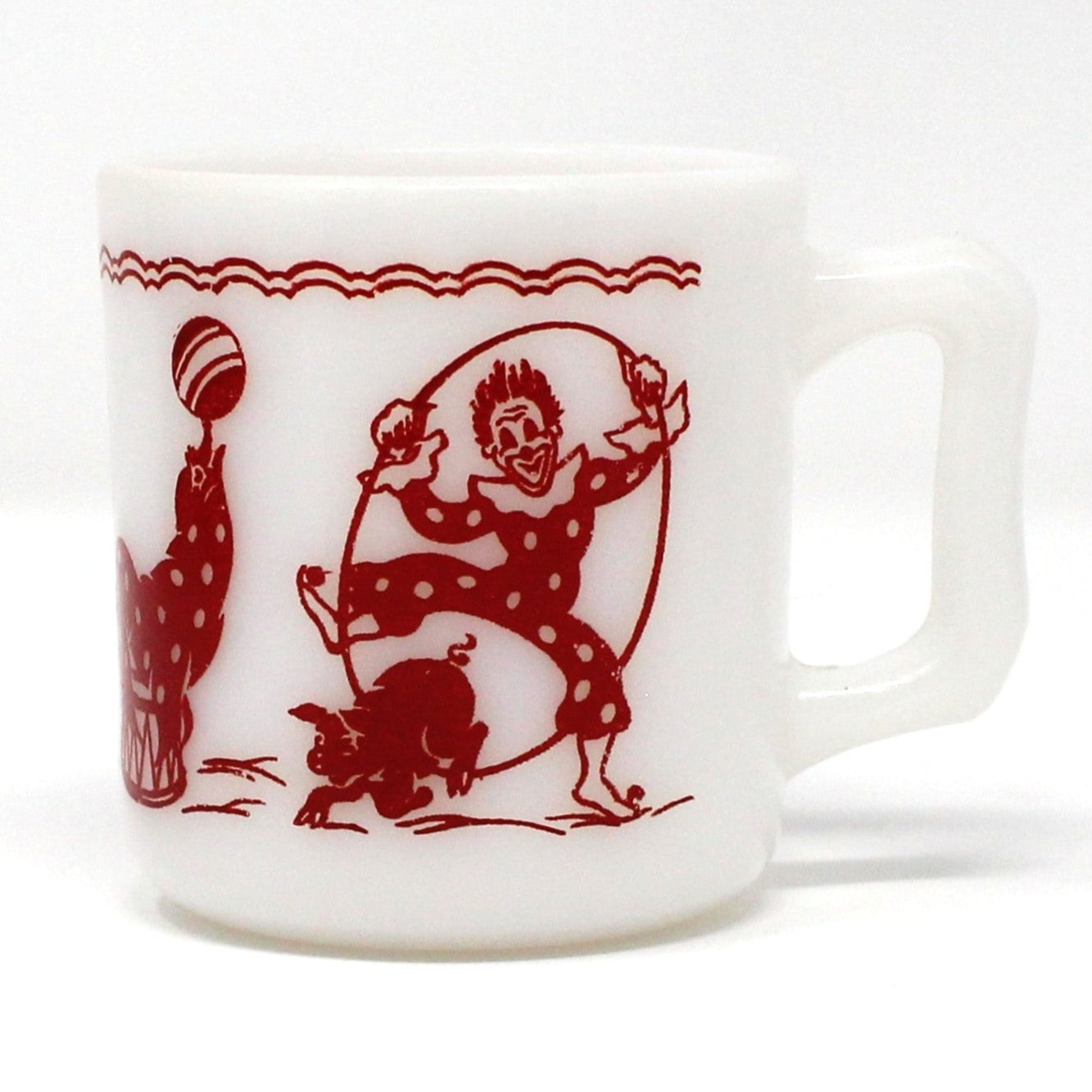 A vintage white Hazel Atlas milk glass child's mug with red enamel circus clown graphics.