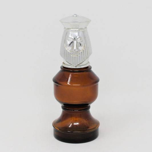 A vintage Avon after-shave decanter with a brown glass body and a silver top resembling a king chess piece.