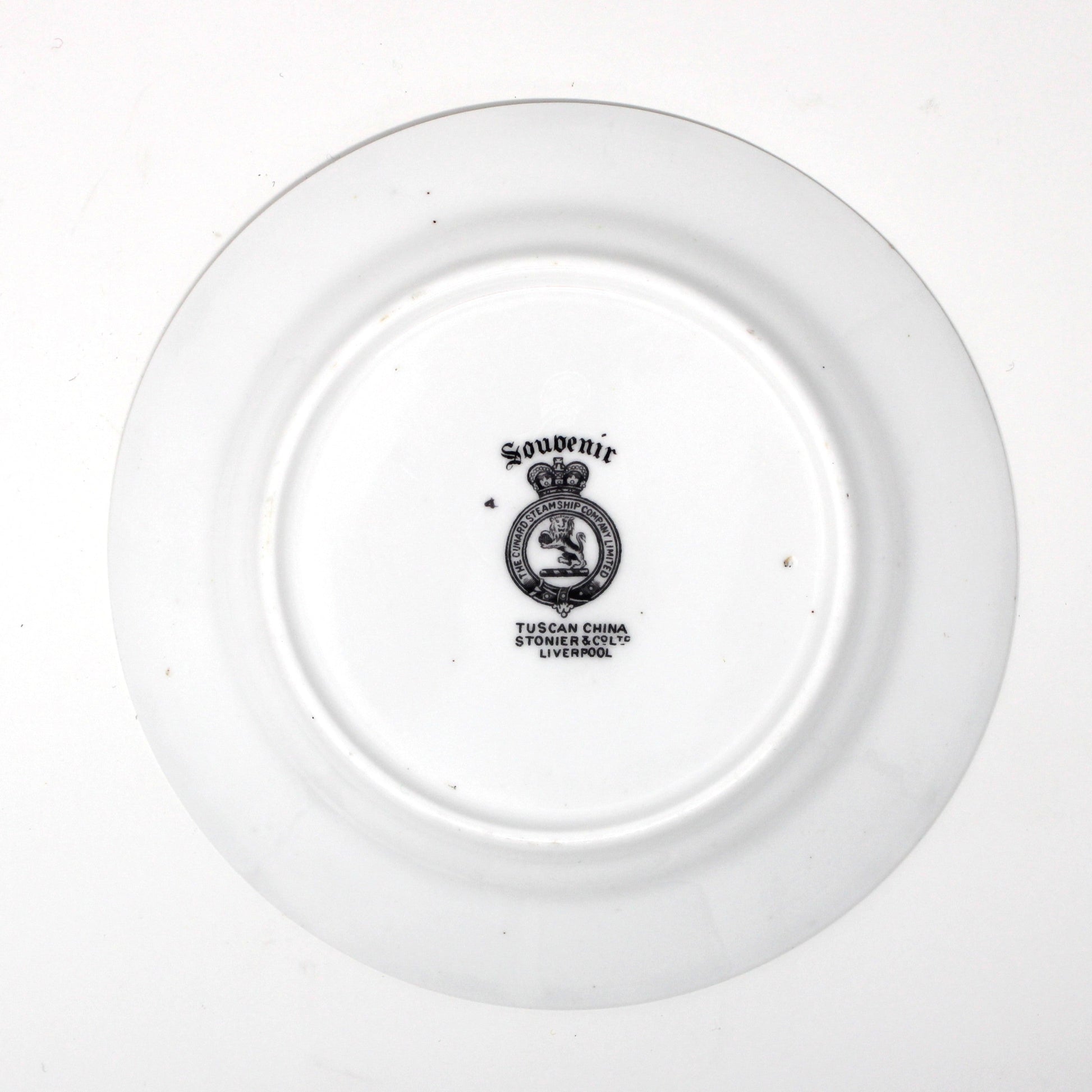 backside of antique plate with a logo on a white background