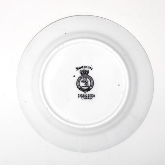 backside of antique plate with a logo on a white background