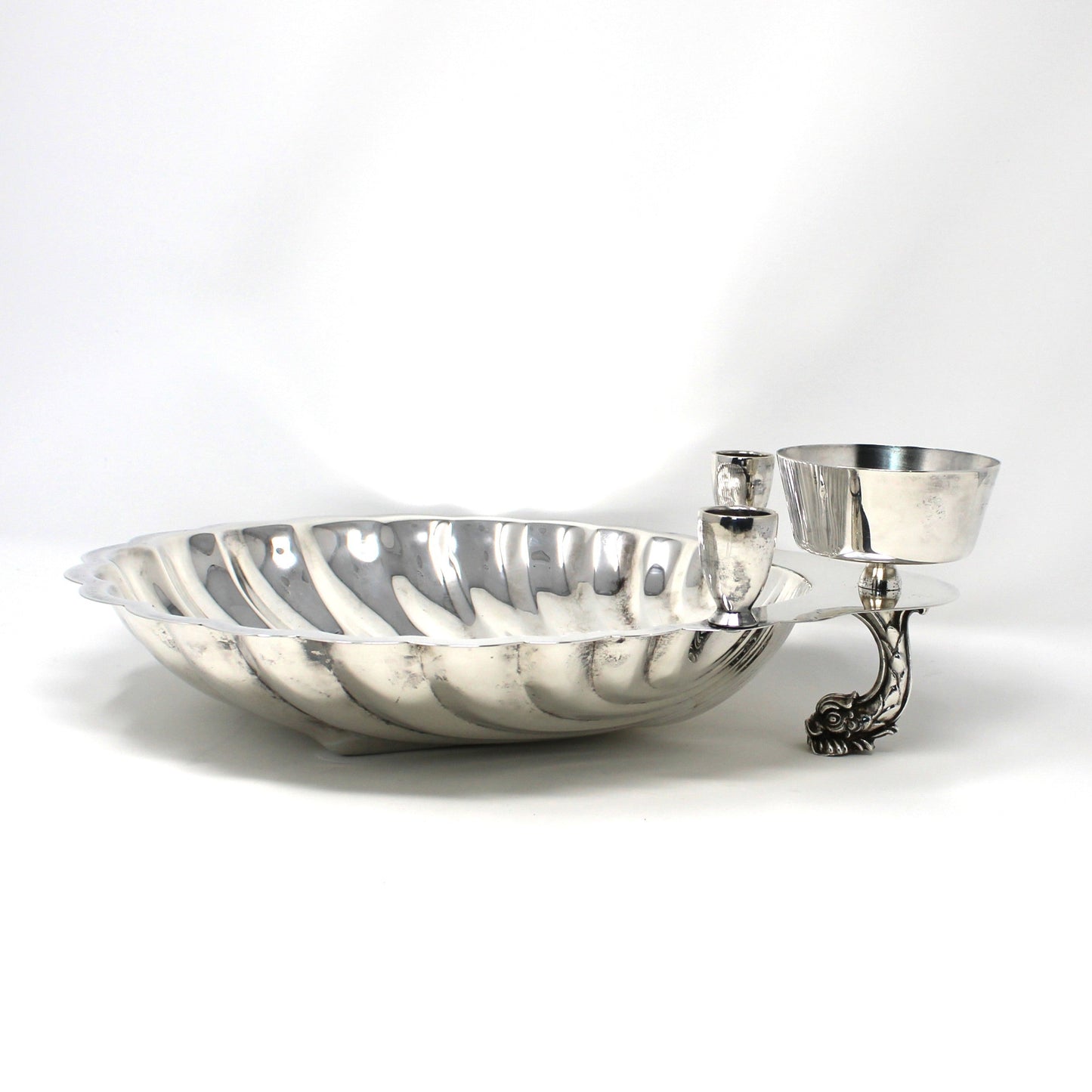 Silver clam shell shaped bowl with a dolphin shaped foot