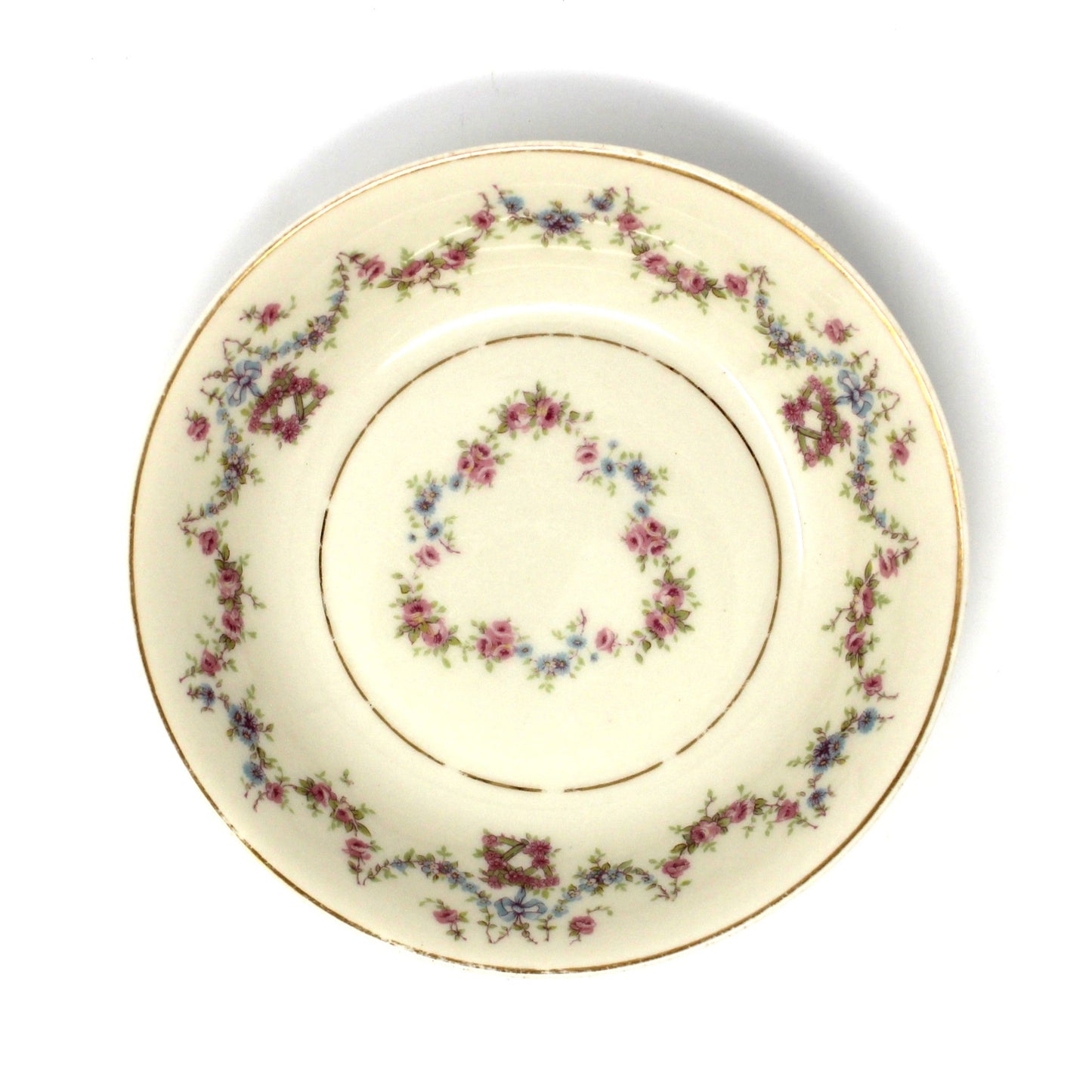 Decorative ceramic plate with pink and blue floral pattern on a beige background