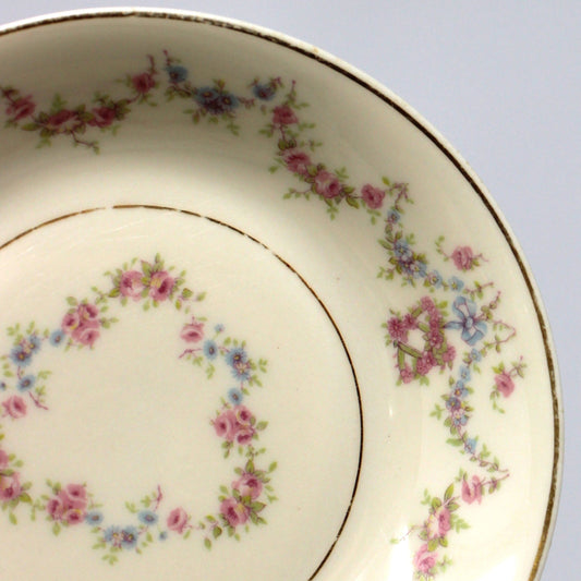 Decorative ceramic plate with romantic floral patterns in blue and pink, on a beige background