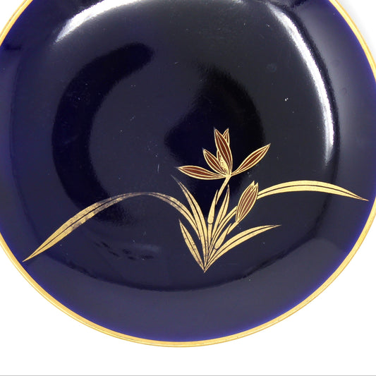 Navy blue plate with gold floral design on a white background