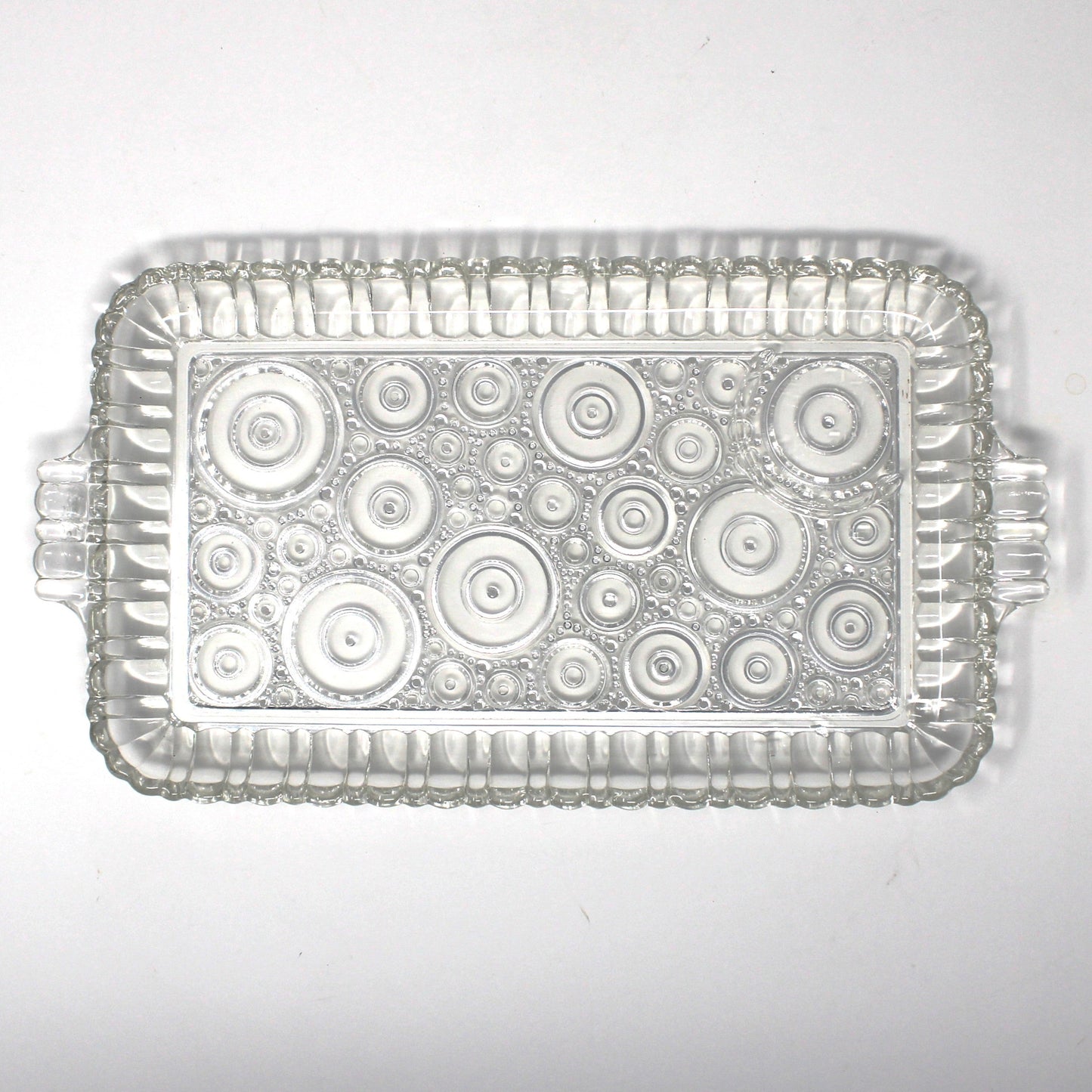 Clear glass snack tray from Anchor Hocking Serva Snack set. Geometric circles pattern called Colonial Lady.