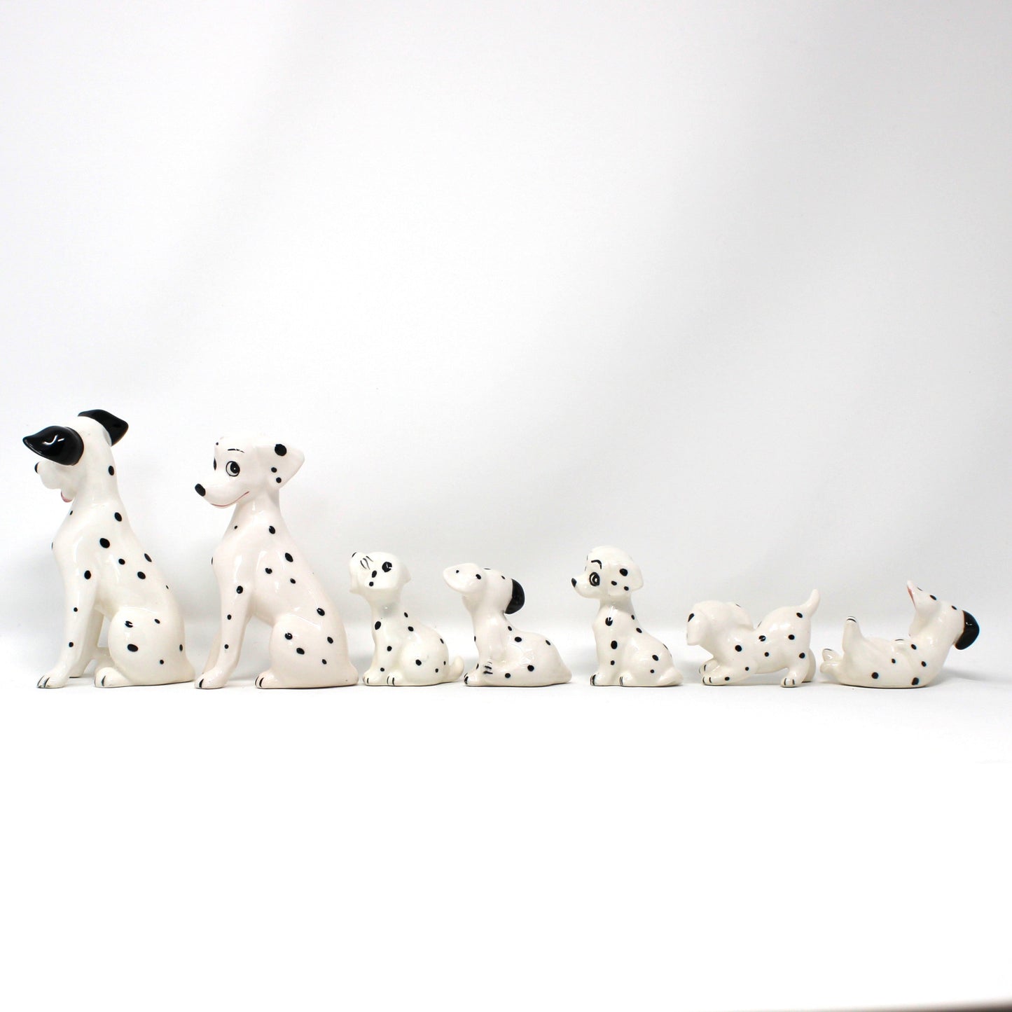 Row of Dalmatian dog figurines on a white background