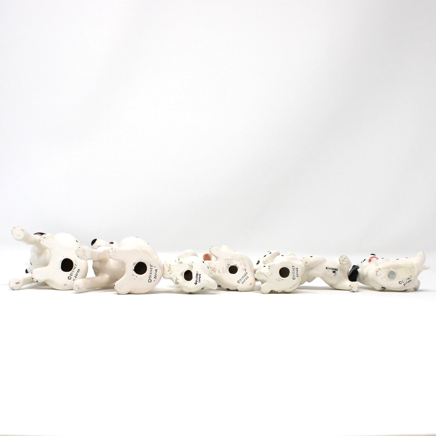 Bottom view of Vintage Disney figurines. Set of 7 101 Dalmatians dogs.