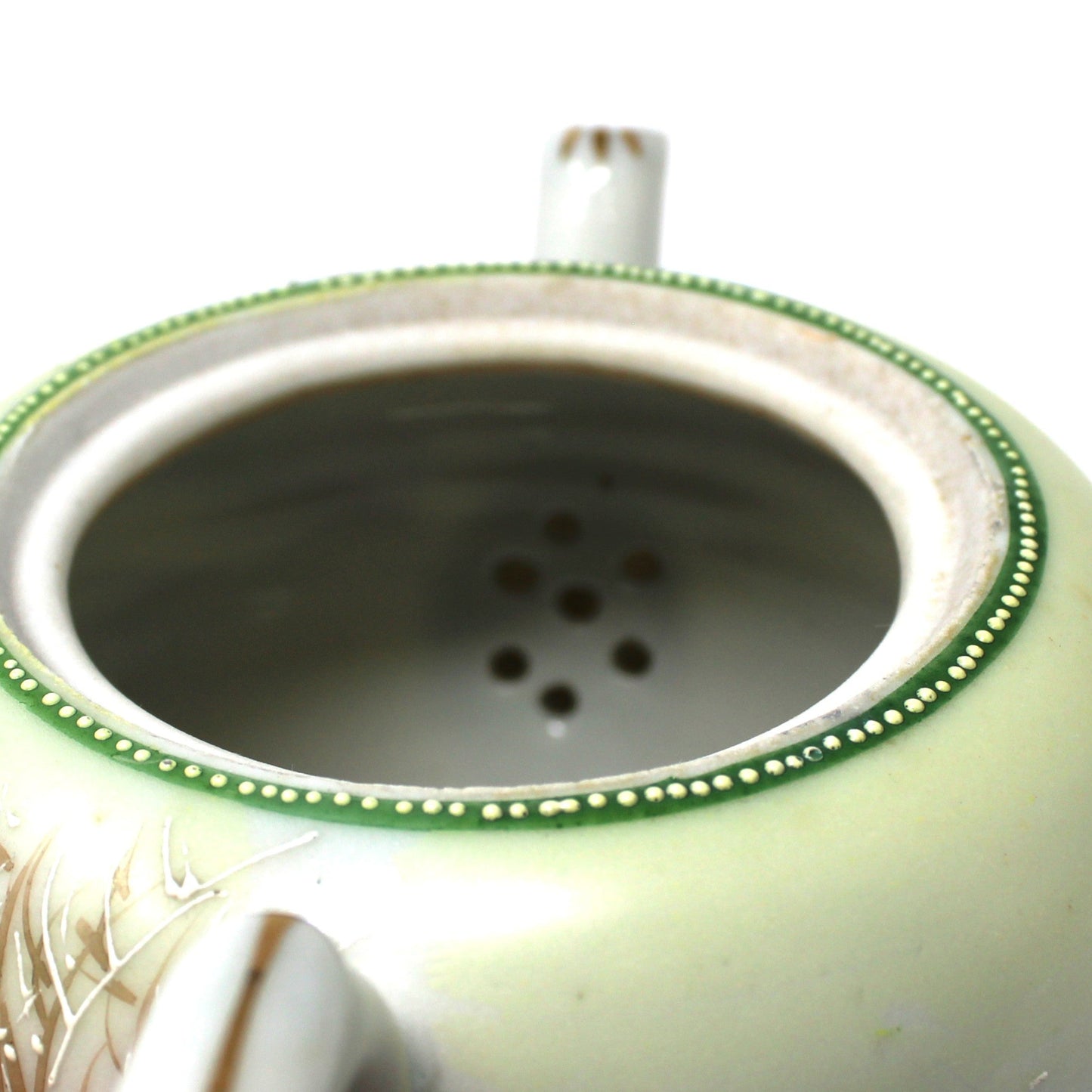 close up view of internal strainer on teapot.
