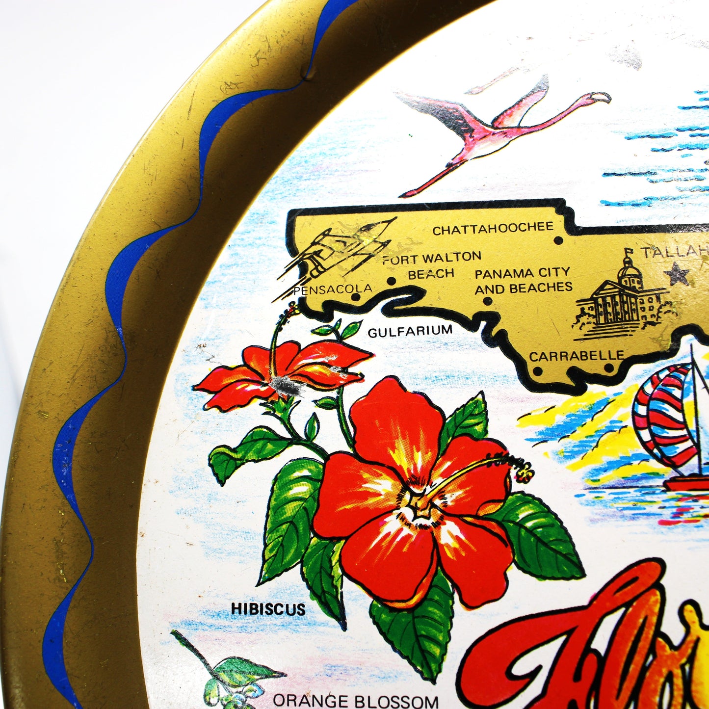Decorative vintage tin tray with a map of Florida, flowers, and sailing boat design on a white background.