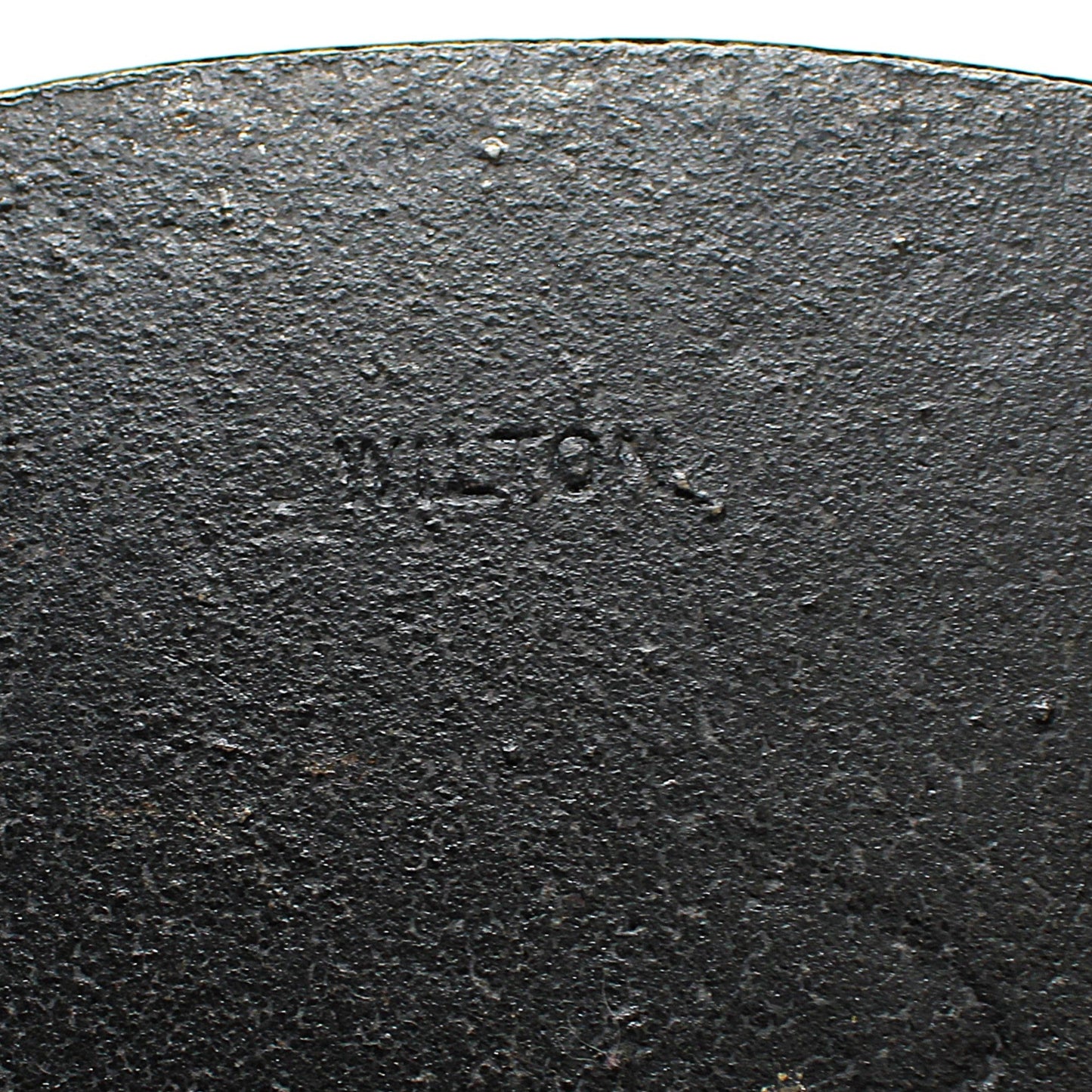 Close-up of a black cast iron bookend with 'Wilton' branding