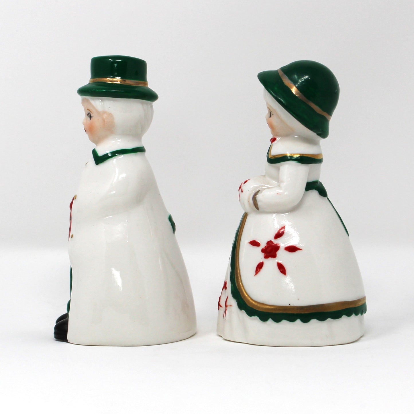 Two vintage porcelain figure bells. Victorian couple, both with green hats and red and white gowns.