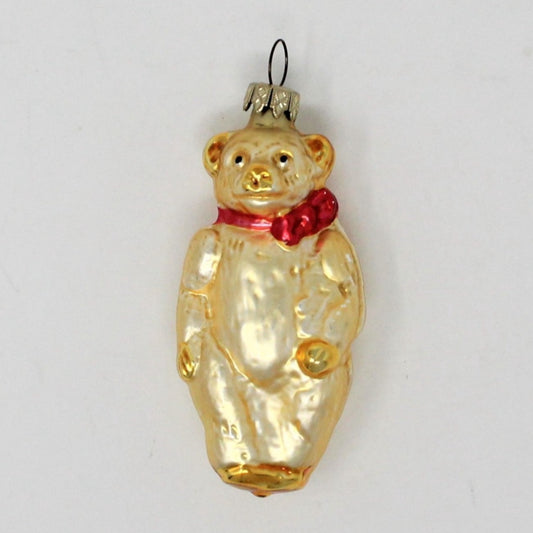 A vintage mercury glass German ornament depicting a teddy bear with a red bow, mouth blown and hand painted, with a metallic gold finish and a Whitehurst cap.