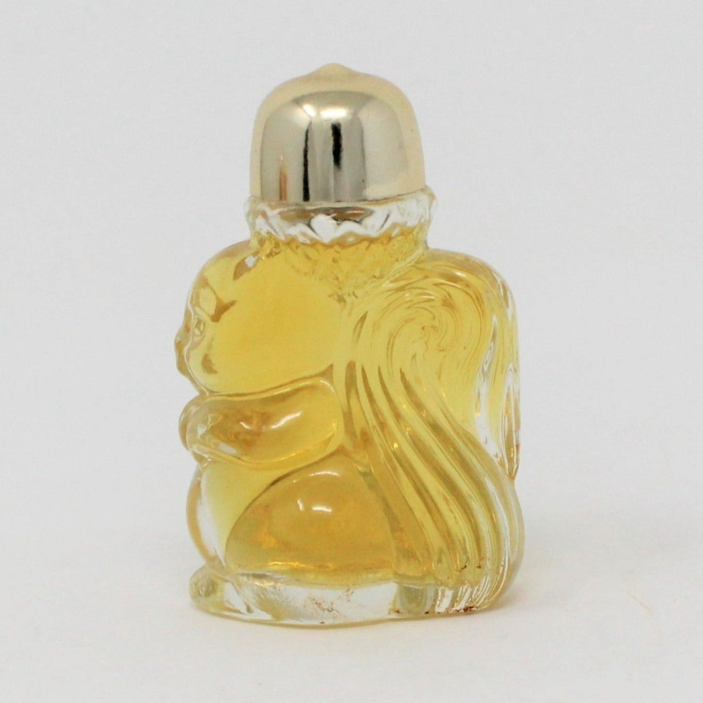 A miniature Avon perfume bottle shaped like a squirrel with a gold-tone acorn lid on top, containing a yellow-colored liquid.