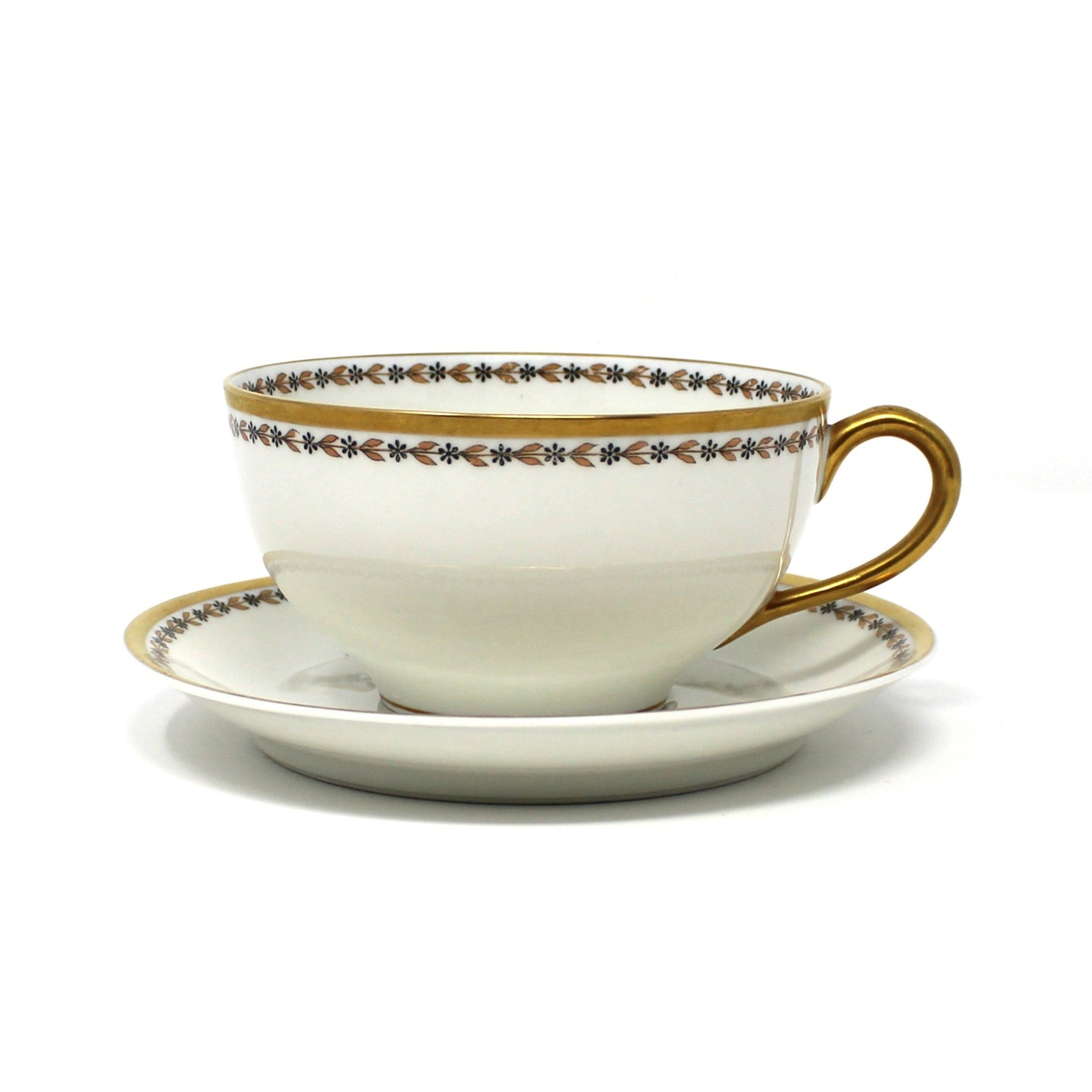 Antique porcelain teacup and saucer by Haviland & Co, Limoges. With decorative trim, gold laurel leaves and black flowers.