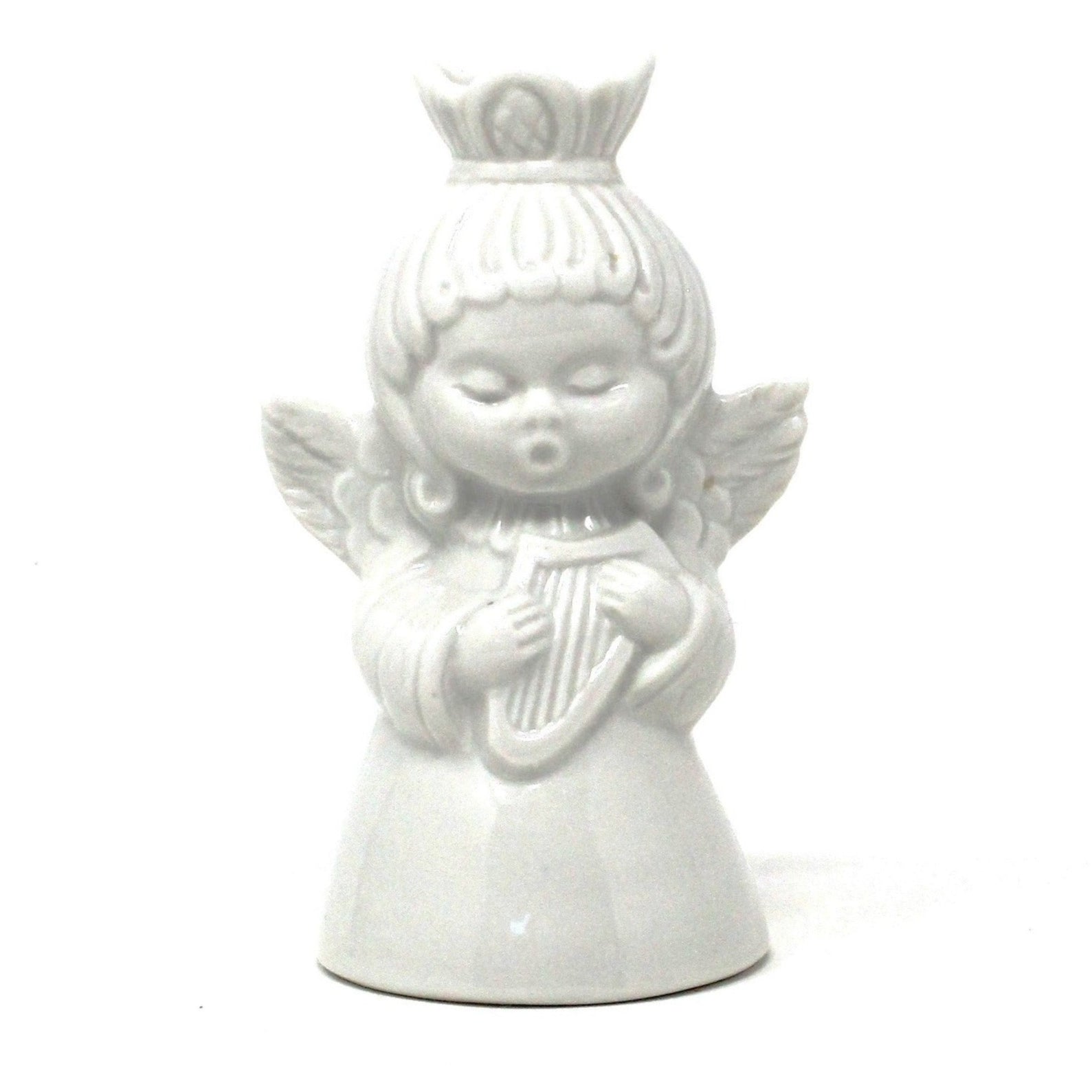 A vintage white porcelain Dresden Angel candle holder playing a harp.