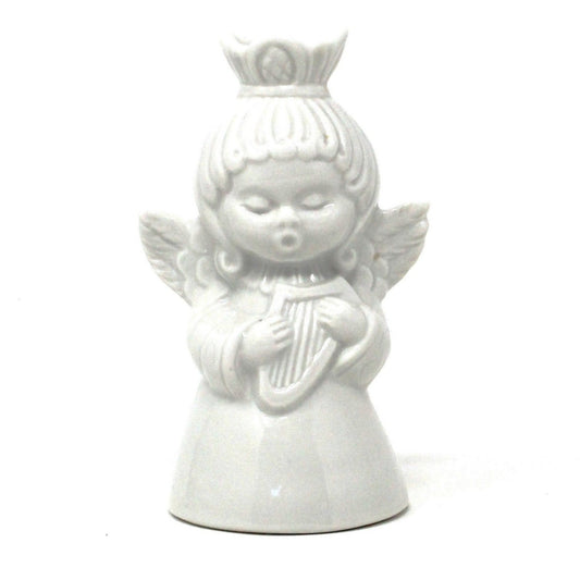 A vintage white porcelain Dresden Angel candle holder playing a harp.