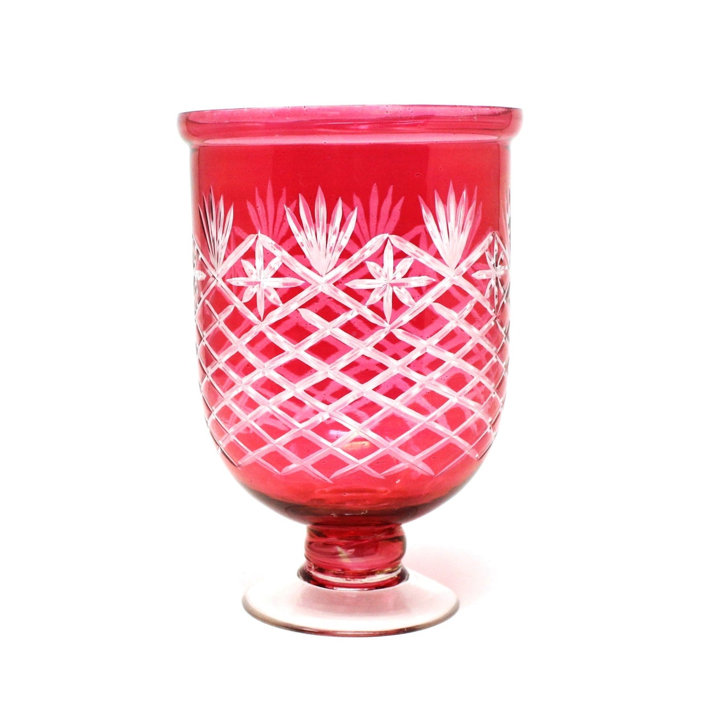 A vibrant ruby red cut glass vase with clear feet, featuring a geometric pattern of cuts like starbursts and fans.