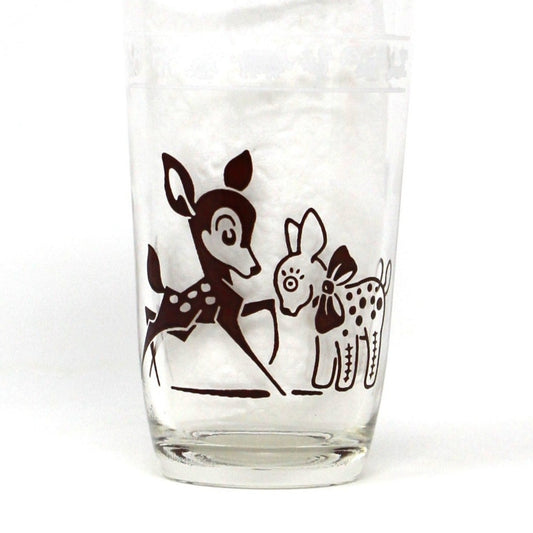 A vintage Hazel Atlas Swanky Swigs glass with brown enamel designs of a deer and a squirrel.