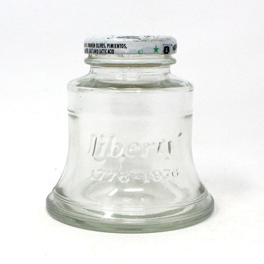 A clear glass jar with a metal lid, labeled 'Liberty 1776 - 1976, indicating it is a vintage item from the 1970s.