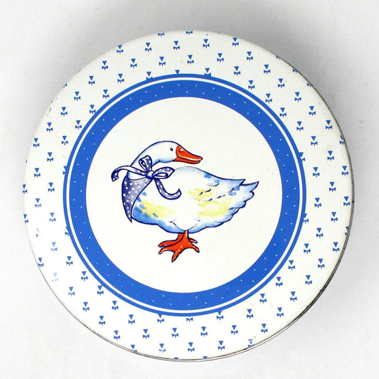 Round ceramic cookie tin, Blue and White with a white goose wearing a blue bandana.  The sides have yellow baby geese.