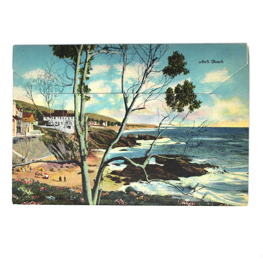 A vintage postcard souvenir photobook, featuring a coastal landscape scene with rocky shoreline, ocean waves, trees, and buildings, from Mid Century Laguna Beach, CA.