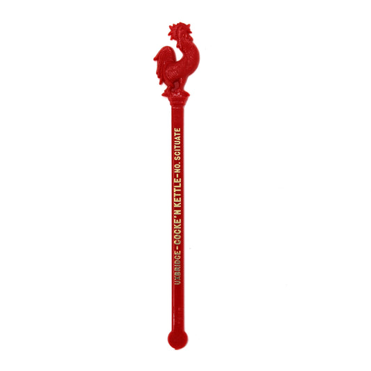 A vintage swizzle stick, with a red rooster figure on top and gold text reading 'UXBRIDGE-COCKE'N KETTLE- No. Scituate.