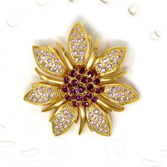 Gold flower-shaped brooch with purple center and lilac gemstones on gold tone.