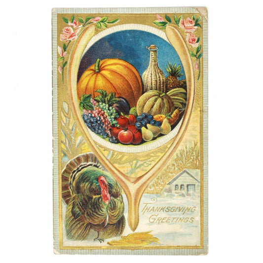 Antique embossed and gilded Thanksgiving postcard featuring an illustration of harvest fruits and vegetables, a wishbone, and a turkey with a snowy cabin scene on the bottom, all in a decorative frame with pink roses at the corners.