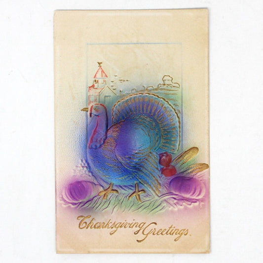 Antique Thanksgiving postcard featuring an embossed and gilded illustration of a turkey with pumpkins and corn, air brushed in lavender and blue, with 'Thanksgiving Greetings' text.
