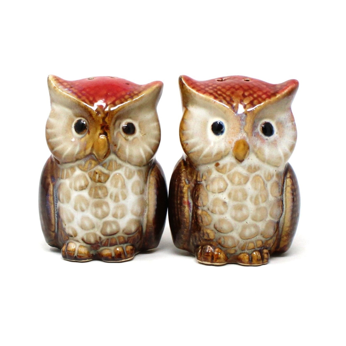 A pair of vintage owl-shaped ceramic salt and pepper shakers with red and brown feathers and black eyes.