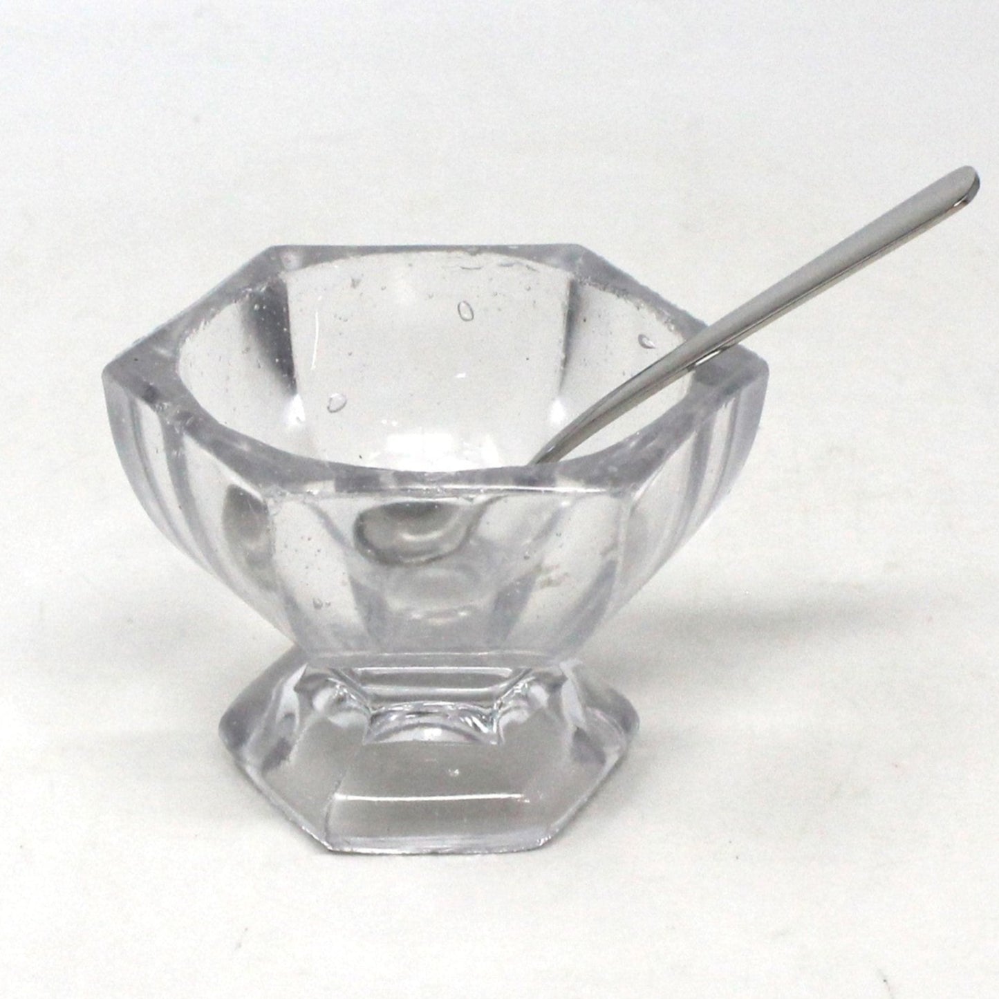 A vintage master salt cellar / salt dip, made of molded blown glass with visible bubbles, with spoon.