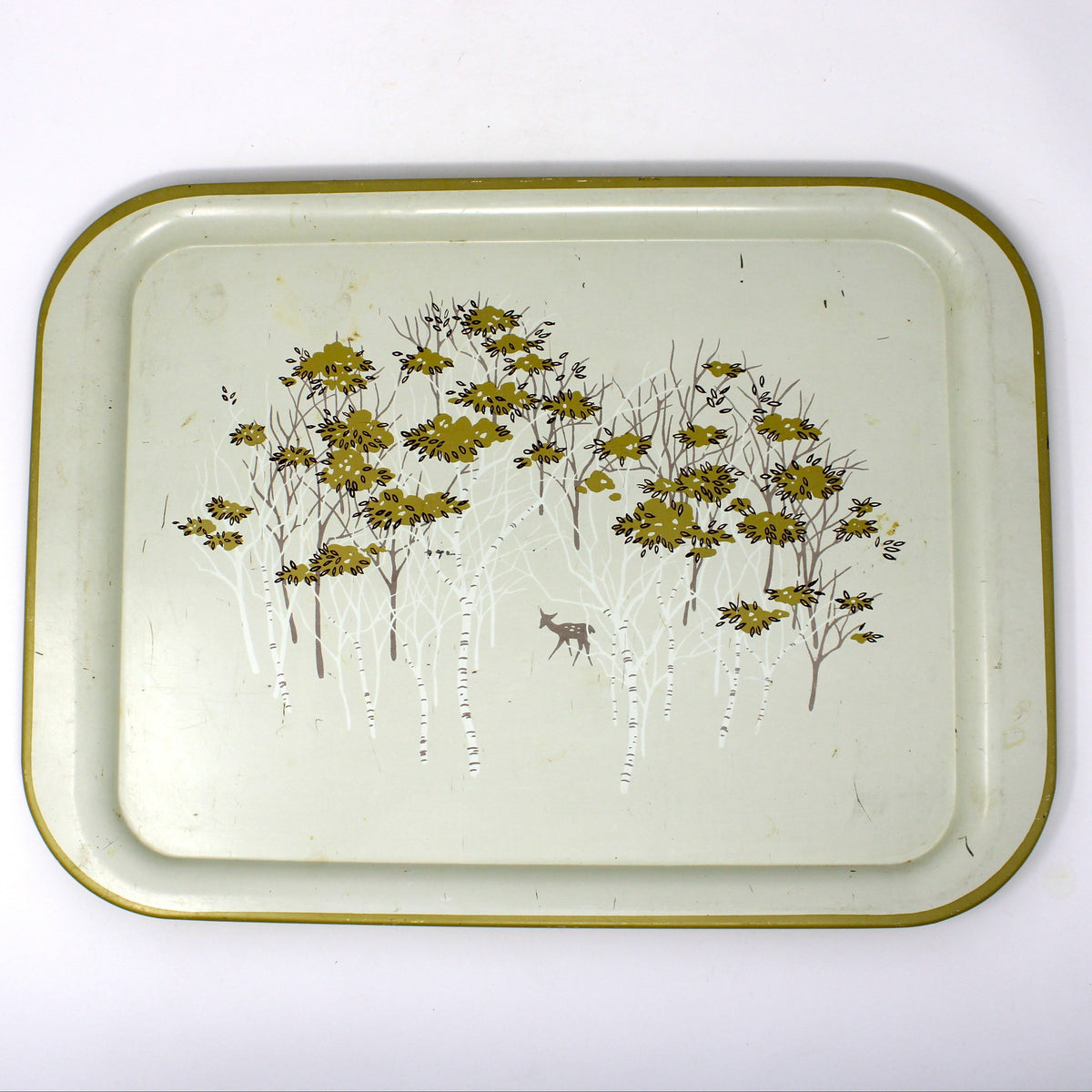 A vintage rectangular metal tray with rounded corners, featuring a gold-toned rim and a printed design of birch trees with golden foliage and a small deer on an off-white background.