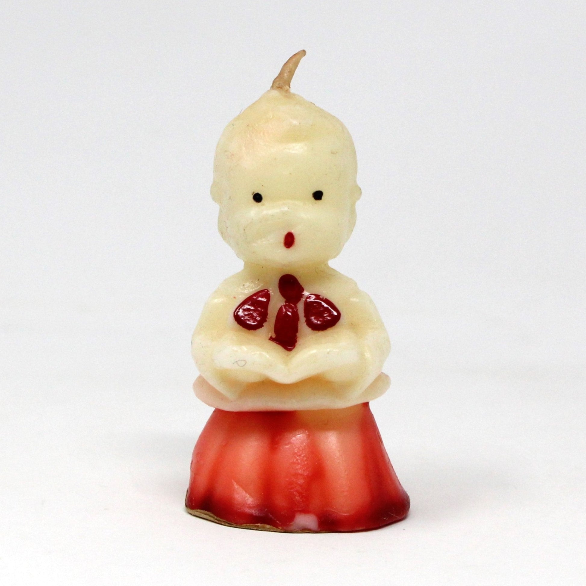 A vintage Gurley decorative candle in the shape of a choir singer boy caroler, with a red and white gown and a red necktie, from the 1950's, unused.