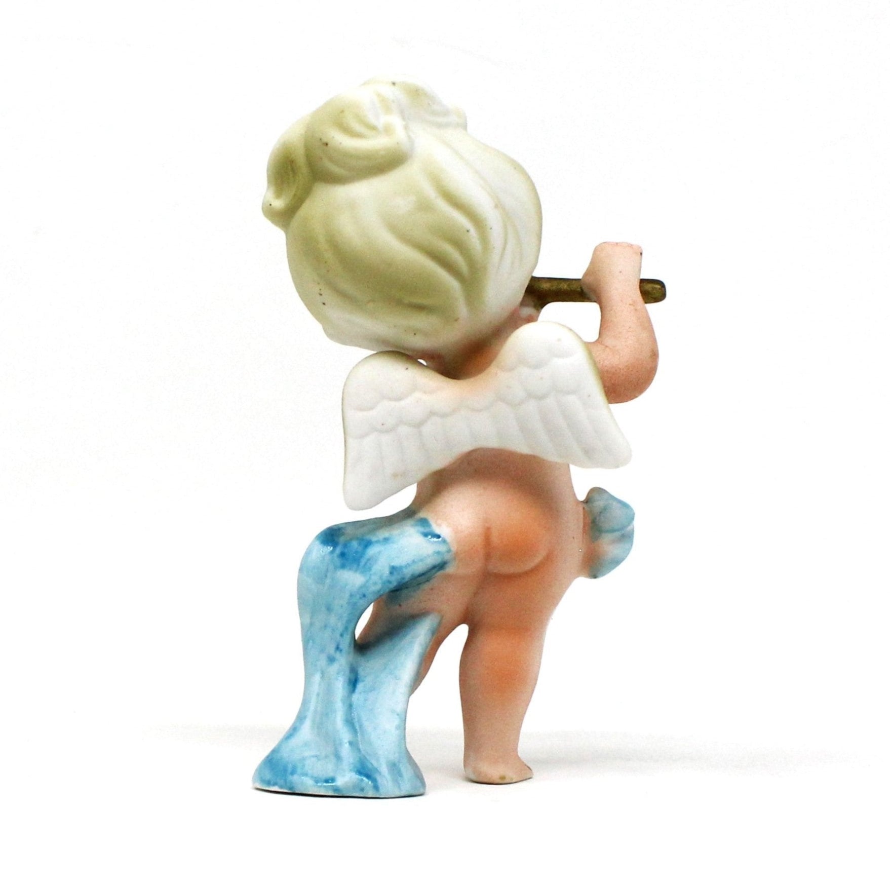 Back view of vintage figurine, angel playing flute wearing a blue sash.