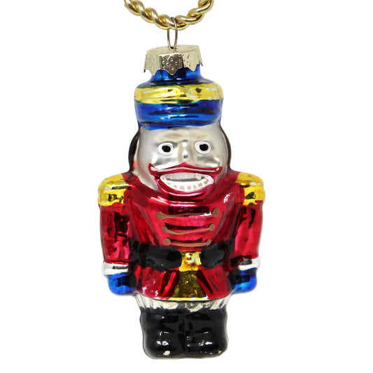 A vintage hand-painted glass ornament.   nutcracker soldier in red, blue, black, gold, and silver colors.