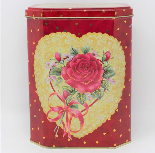 A vintage collectible tin with a pink rose and gold hearts design on a red background.  Suitable for storage or as a decorative item.  Valentine's Day decor
