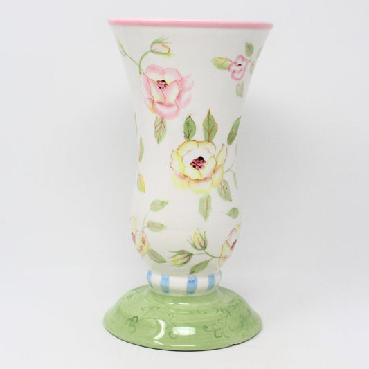 A collectible FTD ceramic vase, with a pastel floral design in pink, yellow, and green colors, featuring a blue and white striped base.