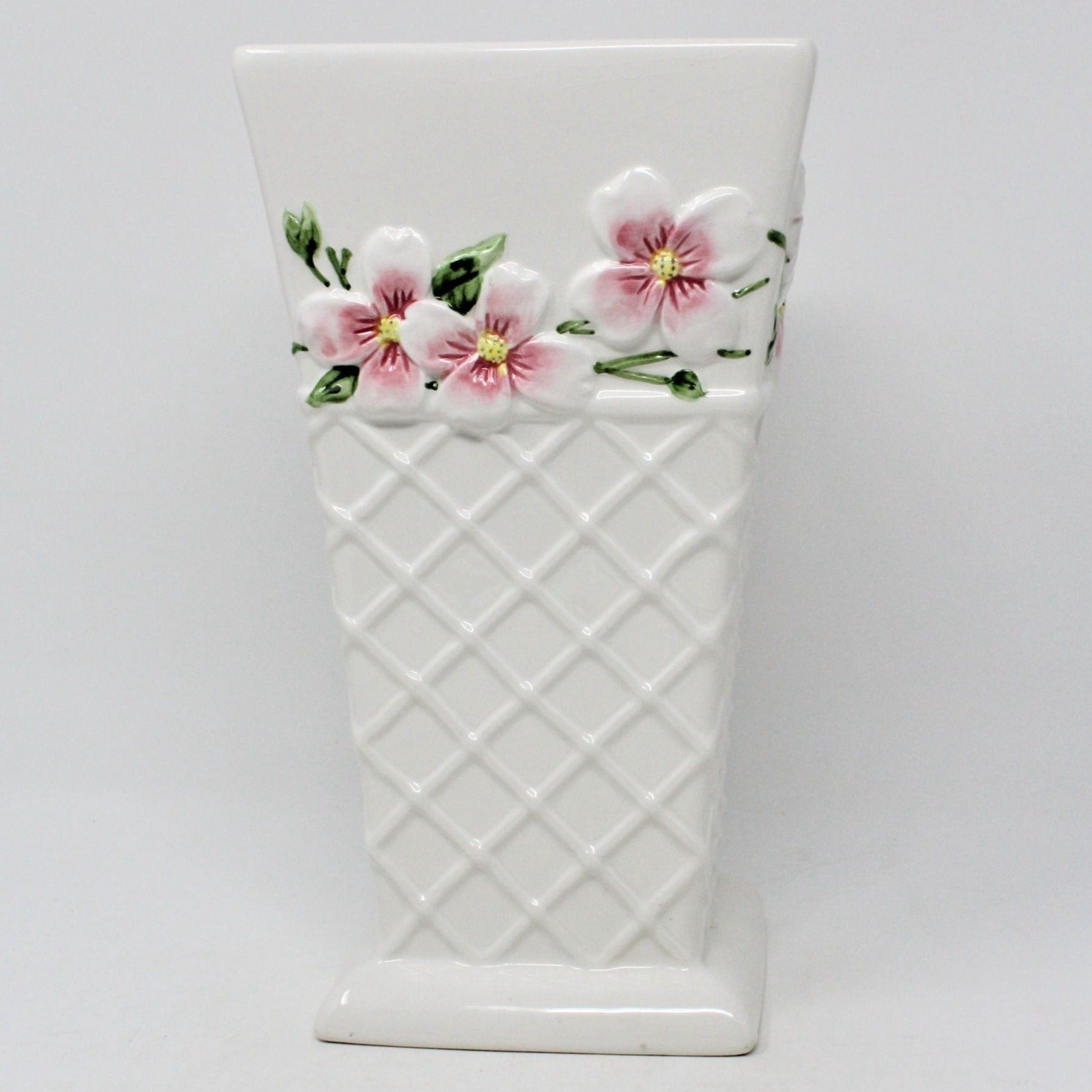 A white ceramic vase from FTD, with a geometric trellis pattern and pink floral designs resembling Apple Blossoms or Pink Dogwood flowers. FTD Collectible