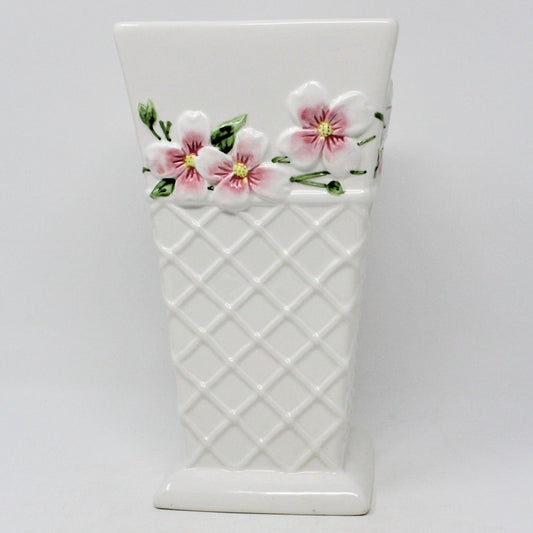 A white ceramic vase from FTD, with a geometric trellis pattern and pink floral designs resembling Apple Blossoms or Pink Dogwood flowers. FTD Collectible