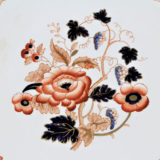 Close up view of center plate design with orange flowers and grape clusters