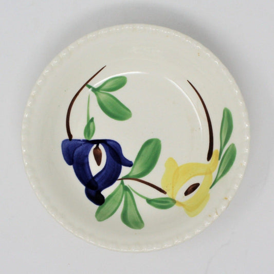 A vintage Blue Ridge Southern Pottery fruit/dessert bowl with a floral pattern featuring blue and yellow flowers, dark green leaves, and a brown stem. The bowl has a candlewick pattern around the border.
