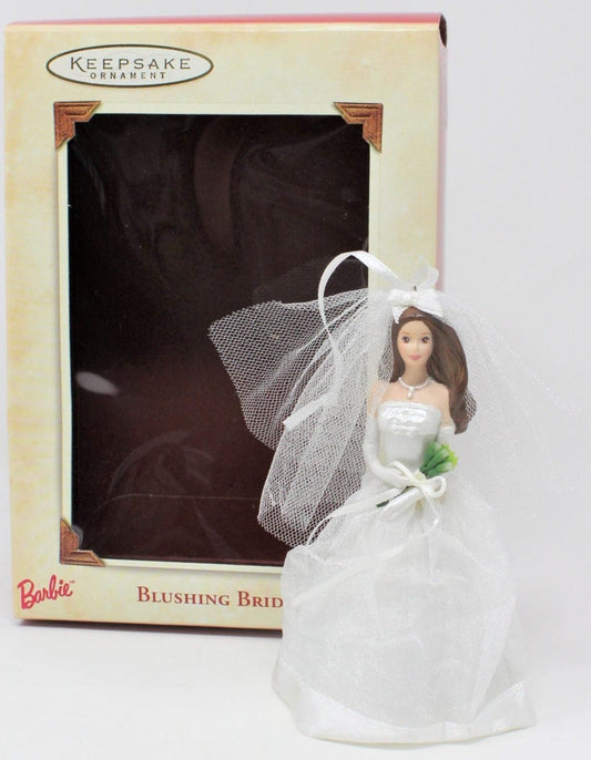 Barbie Bride Christmas ornament in white and silver attire with a veil, holding a small bouquet, displayed with its original packaging. Collectible