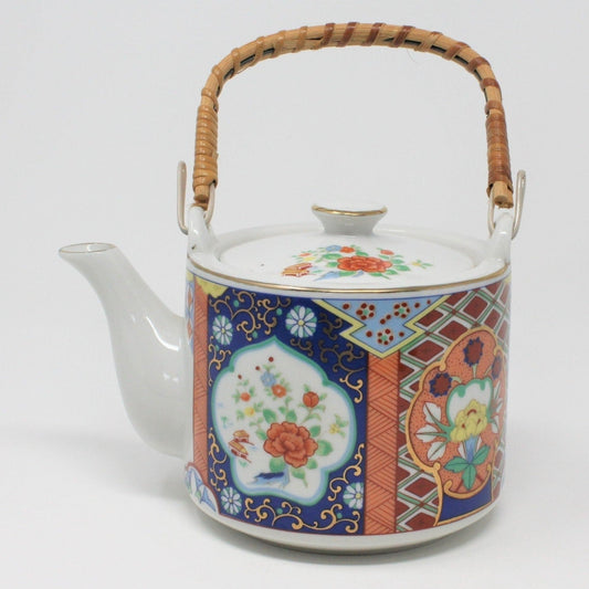 A vintage Miyako Imariware teapot with a bamboo handle and ornate floral patterns on a porcelain body.