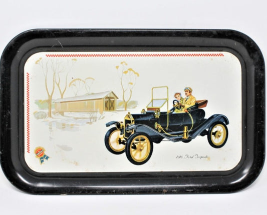 Vintage metal tray with a illustration of a 1910 Ford Torpedo Roadster and people bundled up for winter.