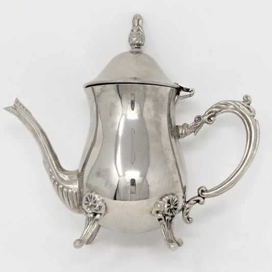 Vintage silverplate teapot with ornate details, footed design, and a hinged lid.