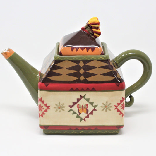 A vintage ceramic Zrike brand coffee pot. "Indian Summer" pattern with a colorful Southwest-inspired geometric pattern, featuring earthy browns, red, mustard yellow, and olive green colors, with a butterfly design on the lid.
