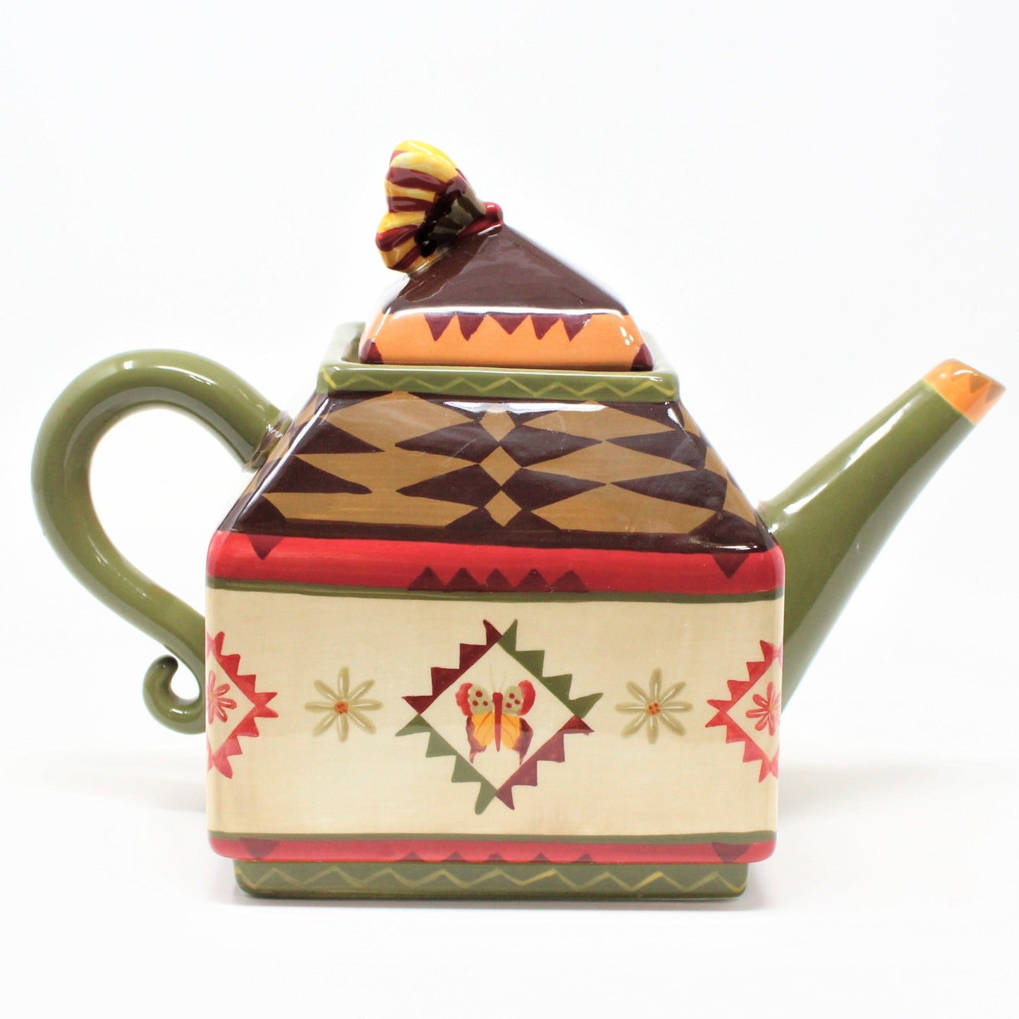 A vintage ceramic Zrike brand coffee pot. "Indian Summer" pattern with a colorful Southwest-inspired geometric pattern, featuring earthy browns, red, mustard yellow, and olive green colors, with a butterfly design on the lid.