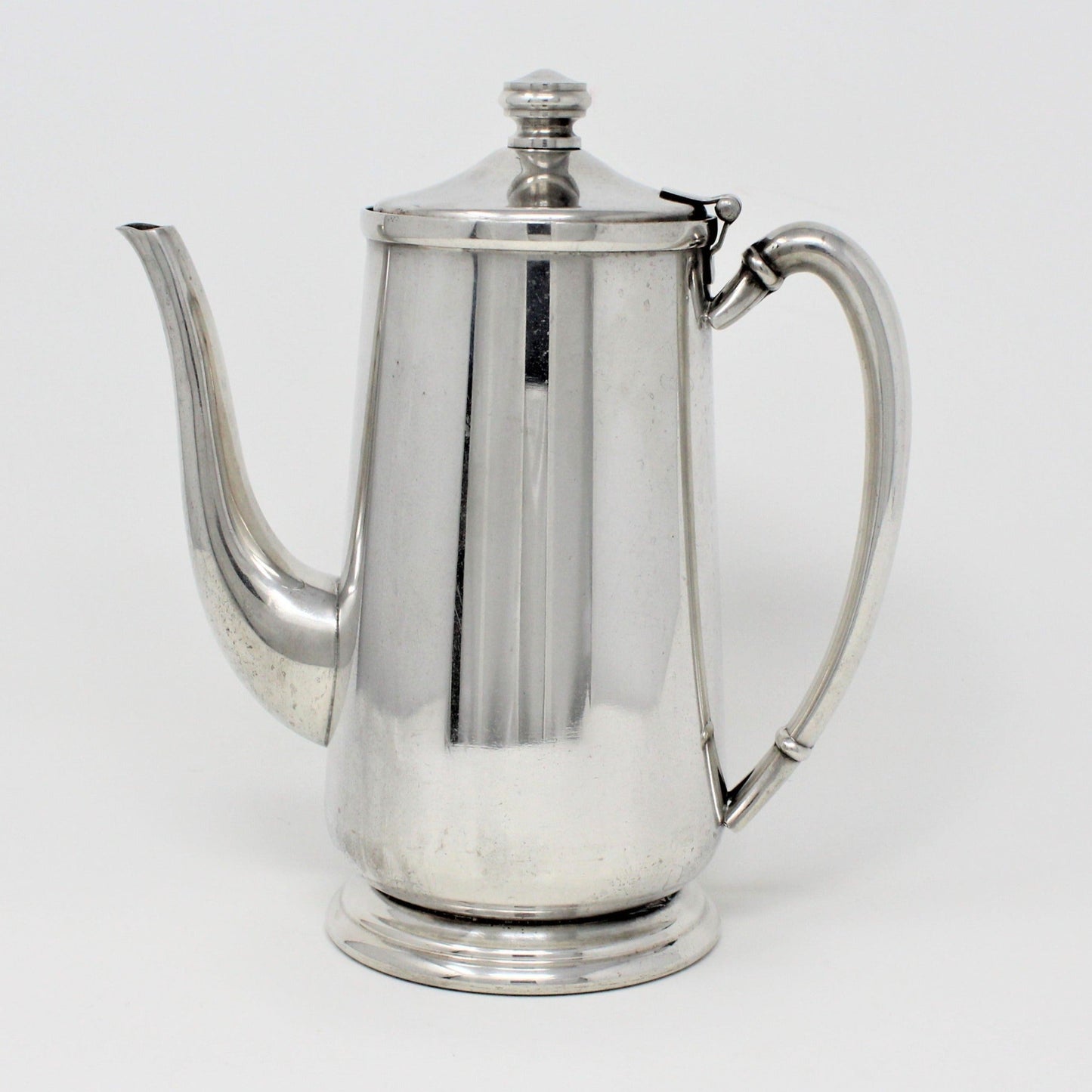 A vintage stainless steel coffee pot with a long spout and handle, standing upright against a white background.